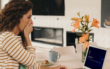 chica asustada al ver pantalla de error en el ordenador