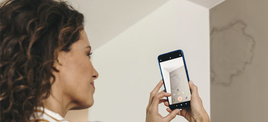 chica haciendo foto con el móvil a una mancha de humedad