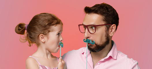 padre e hija jugando con bigotes de cartón