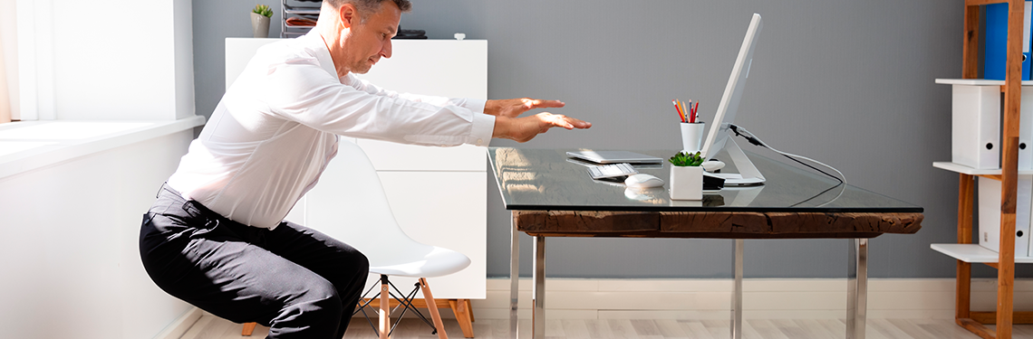 Hombre haciendo una sentadilla en el trabajo