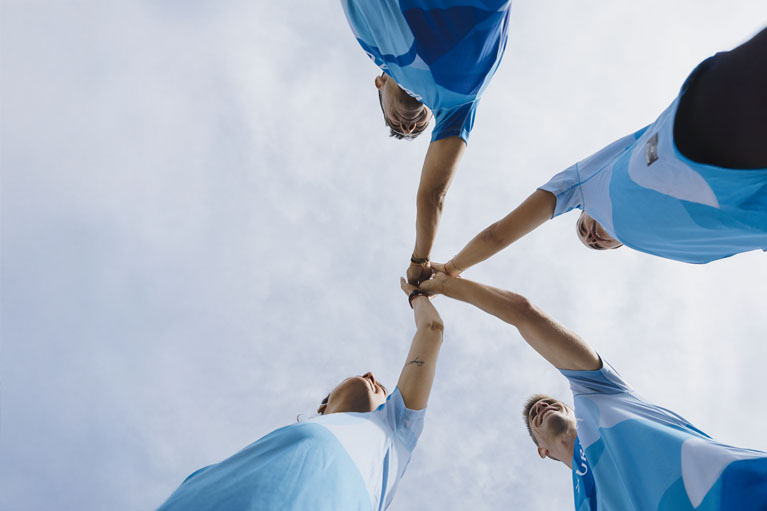 grupo de personas, con la camiseta de deporte Zurich, chocando las manos