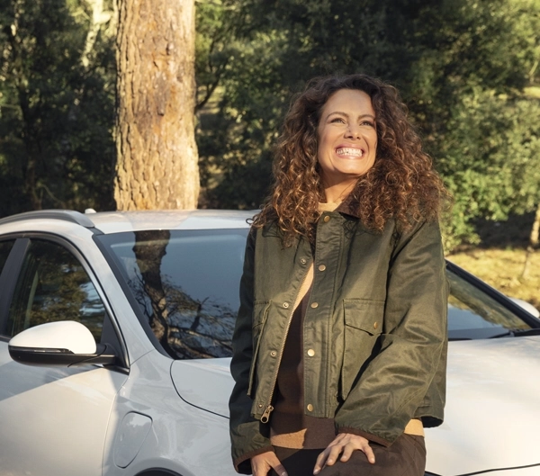 chica sonriendo apoyada en el coche