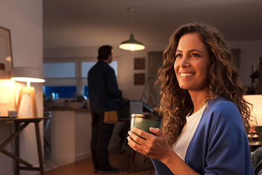 chica sonriente con electricista revisando una lámpara